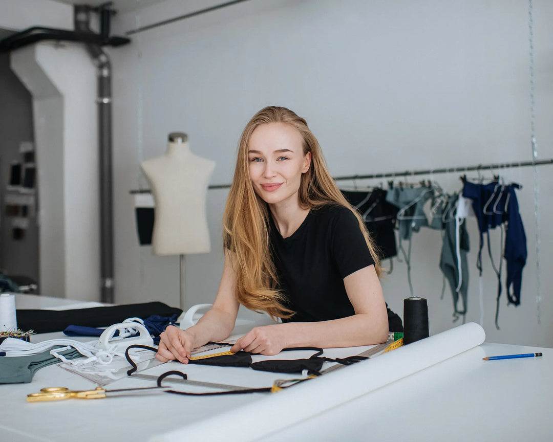 Iida Suutarla our Swimwear Designer smiling behind of the designing table