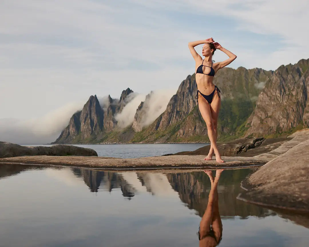 Model in wearing black bikini set photographed outdoors in Norway Lofoten